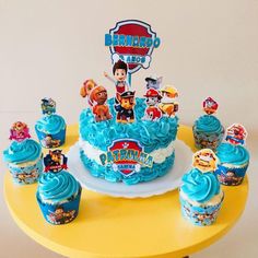 a birthday cake and cupcakes on a table with the characters from paw patrol