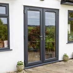 an image of a house that has double doors on the front and side windows in it