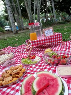 a picnic table with watermelon, crackers, and other foods on it