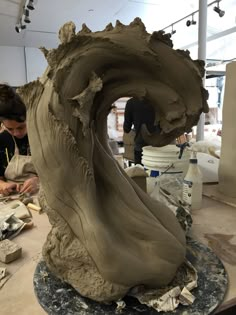 a man is working on a sculpture in the process of making it look like an ocean wave