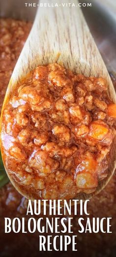 a wooden spoon filled with cooked food on top of a table