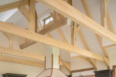 a large kitchen with wooden beams and black cabinets in the center, along with an island