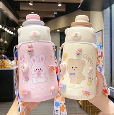 two small bottles with cartoon characters on them, one is pink and the other is white