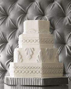 a white wedding cake sitting on top of a table next to a black and white photo