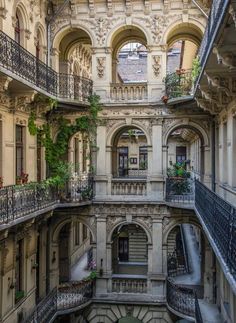 an old building with many balconies and plants growing out of the balconys