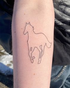 a person with a tattoo on their arm that has a horse drawn on the side