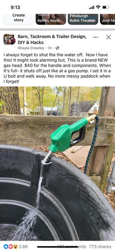 a green blow dryer sitting on top of a wooden fence next to a tree