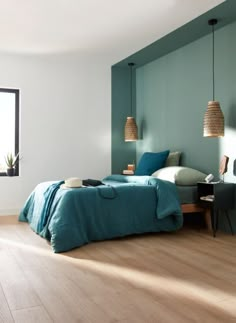 a bedroom with wood flooring and blue bedding in the corner, along with two windows