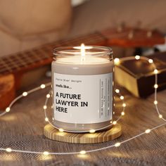 a candle sitting on top of a table next to a string of lights and a guitar