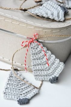 two crocheted ornaments are tied up in twine and placed on top of a box