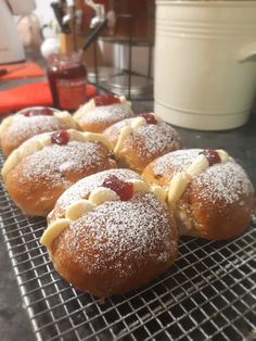 powdered sugar covered pastries sit on a cooling rack