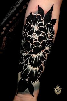 a black and white flower tattoo on the arm