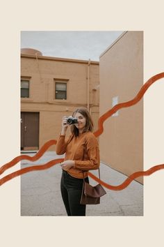 a woman taking a photo with her camera in front of an orange ribbon and building