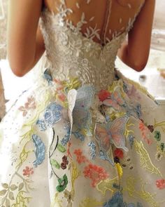 the back of a woman's dress with flowers and butterflies on it, as seen from behind