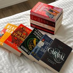 there are five books on the bed and one is in front of the other two