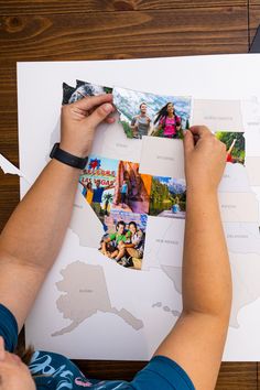 a person cutting out pictures on top of a piece of paper that is laying on a table