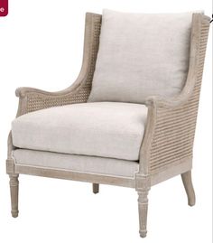 an upholstered chair with white linen and wicker