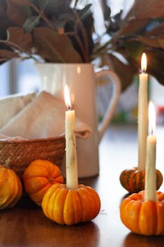 pumpkins and gourds on a table with candles