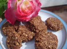 some cookies and a pink flower on a plate