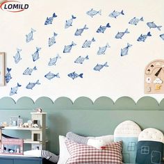 a child's bedroom decorated in blue and white with fish decals on the wall