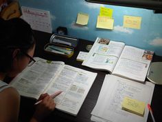 a person sitting at a desk with some books and papers