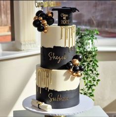 a three tiered cake with black and gold decorations