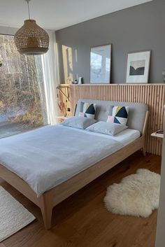 a bedroom with a bed, rugs and pictures hanging on the wall next to it