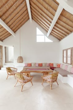 a living room filled with lots of furniture next to a wooden table and two chairs