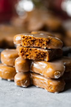 a stack of glazed donuts sitting on top of a table next to each other