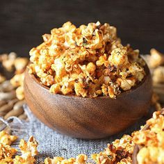 two wooden bowls filled with popcorn on top of a table