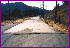 an empty road with mountains in the background and purple border around it that says, there is only one way to go