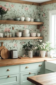 a kitchen with floral wallpaper and wooden shelves filled with pots, pans, and flowers