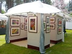 a white tent with pictures on it in the grass