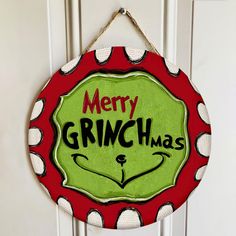 a merry grinch christmas sign hanging on the front door with polka dot trimming