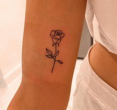 a woman's arm with a single rose tattoo on it