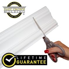 a hand holding a pair of scissors over a white gutter seal with the words baby crown molding on it