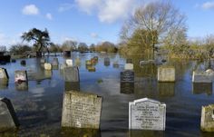 flooded cemetery with headstones and trees in the background