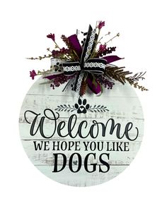 a wooden sign that says welcome we hope you like dogs with flowers and ribbons on it