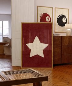 a room filled with furniture and pictures on the wall next to a wooden table in front of a window