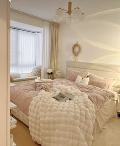 a bedroom with a large bed covered in white fluffy blankets