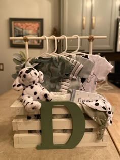 a stuffed dalmatian dog sitting on top of a wooden crate next to a letter d