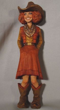 a figurine of a woman wearing a cowboy hat and dress