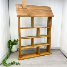 a wooden shelf sitting next to a potted plant