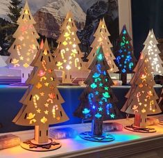 lighted christmas trees on display in front of a window