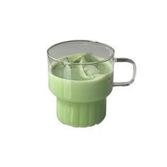 a cup filled with green liquid on top of a table