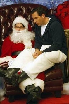 a man sitting in a chair next to a santa clause