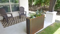 two chairs are sitting on the front porch with plants in them and an area rug