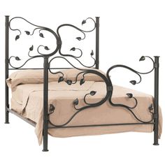 an iron bed frame with flowers on the headboard and foot board, is shown