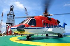 a red and white helicopter sitting on top of an airport tarmac