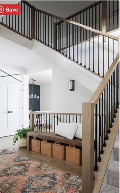 an entryway with stairs and storage boxes under the bannister in this modern home